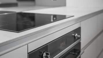 A modern kitchen with a sleek countertop, a built-in oven, and a stainless steel range hood.