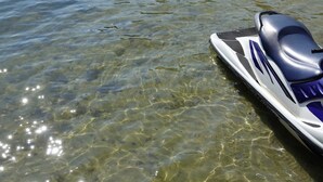 A jet ski partially submerged in clear water.