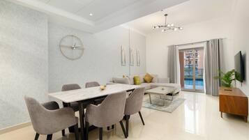 Un salon moderne comprenant un coin repas, un canapé, un téléviseur et un balcon avec vue.