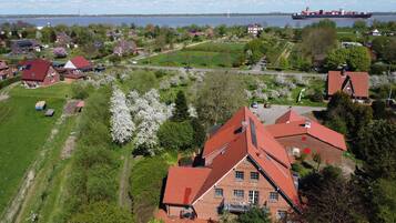 Ett bostadsområde med hus, en stor sjö eller ett stort vattendrag och ett lastfartyg i fjärran.