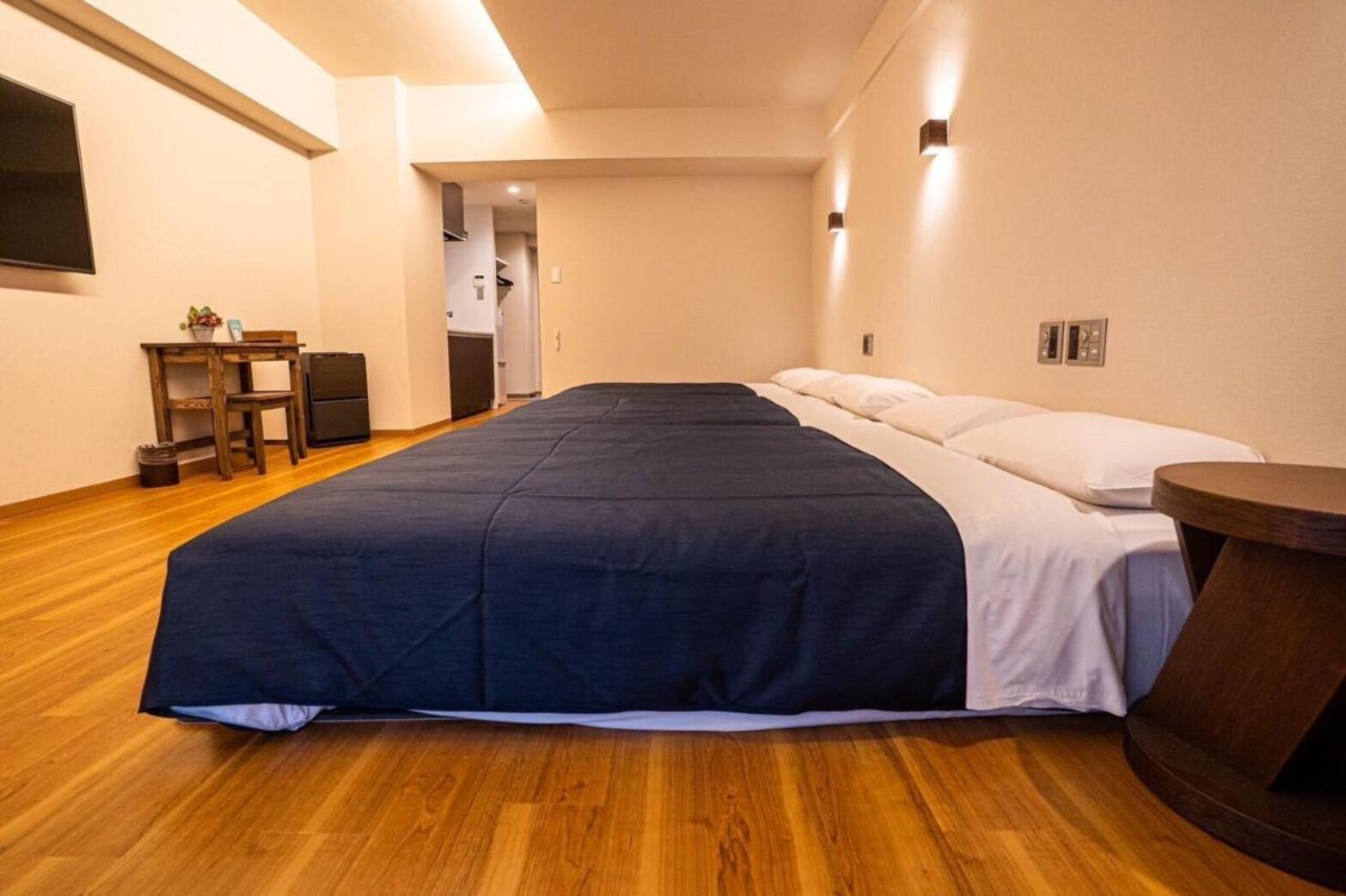 Un dormitorio con una cama grande, una mesita y una silla.