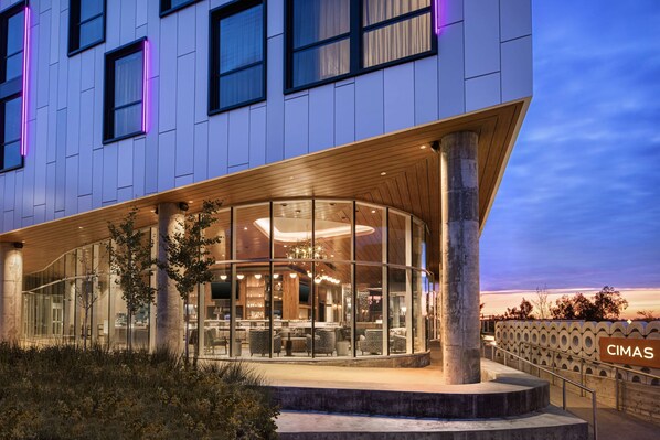 A modern hotel with a glass facade, a wooden overhang, and a sign reading "CIMAS". - Hyatt Centric Beale Street Memphis (Memphis)