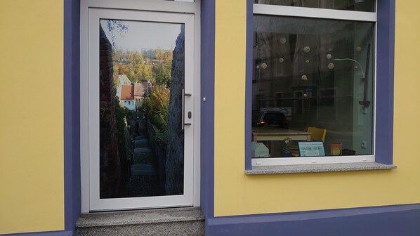 A yellow building with a white door and a window. - Vacation apartment in the heart of the city, on the edge of the historic old town - 00 Children (Bautzen)
