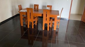 Zona pranzo con un tavolo rettangolare e sei sedie in legno.