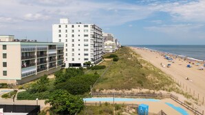 A beachfront hotel with multiple floors, a sandy beach, and a swimming pool. - Direct oceanfront in convenient mid town location (Ocean City)