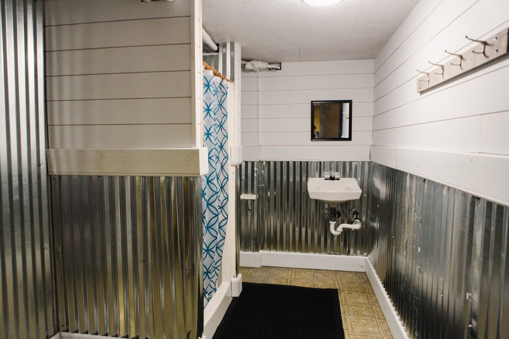 Une salle de bain avec une douche, un lavabo et un miroir.