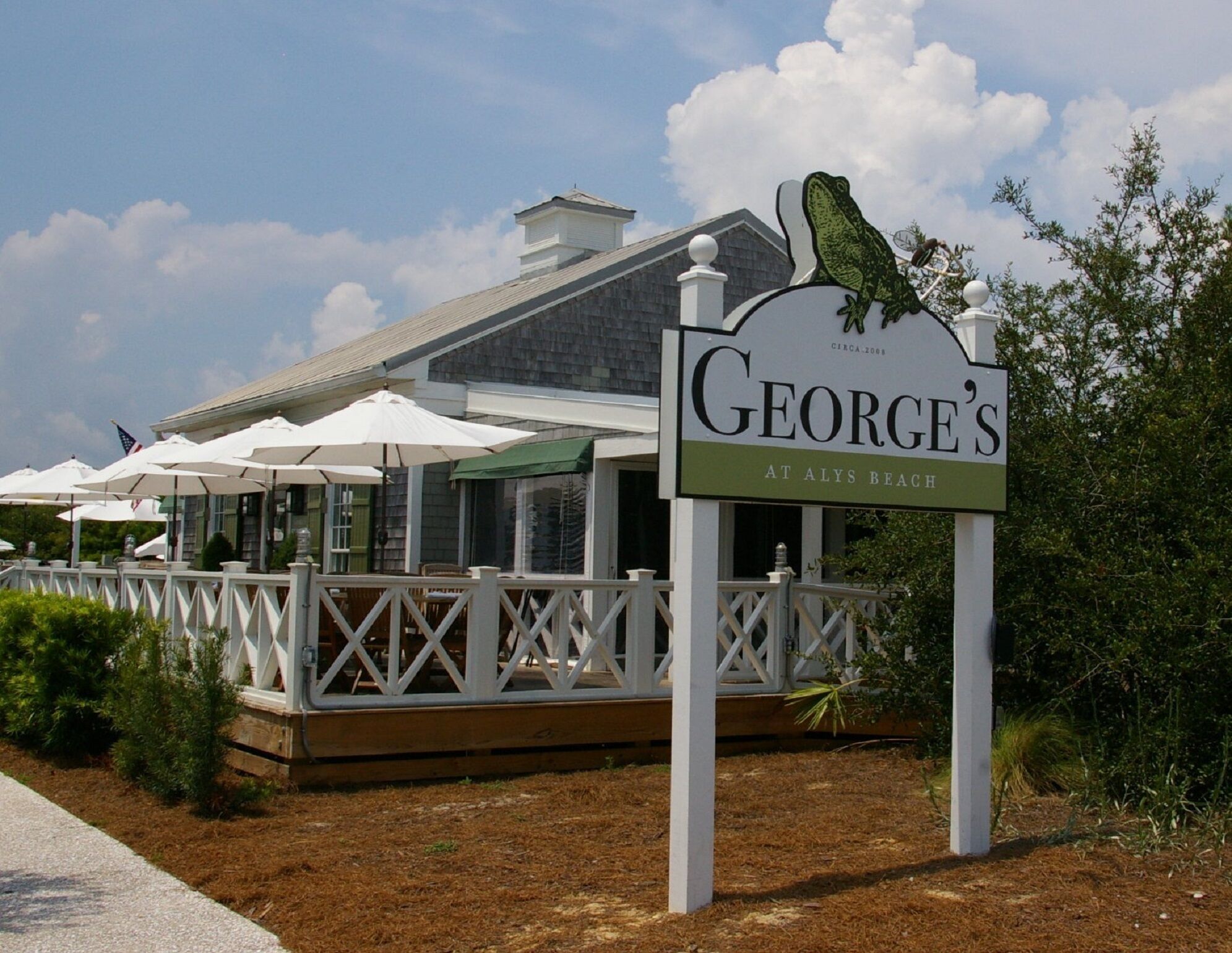 A restaurant named 'George's at Aly's Beach' with outdoor seating and umbrellas.
