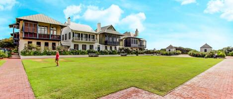A large, multi-story building with a spacious lawn and brick pathways.