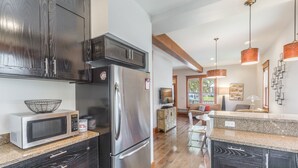 Una cocina moderna con armarios de madera oscura, electrodomésticos de acero inoxidable y encimera de granito.