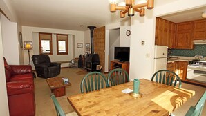 A living room with a fireplace, a TV, and a dining area with a wooden table and chairs. - Next to Ouray Hot Springs | Walk to Main Street | Deck (Ouray)