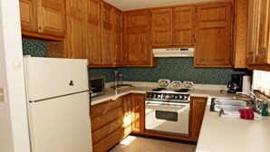 A kitchen with wooden cabinets, a white refrigerator, a stove, and a microwave. - Next to Ouray Hot Springs | Walk to Main Street | Deck (Ouray)