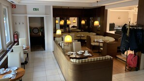 Un vestíbulo de hotel con una zona de estar central, un extintor y un perchero.