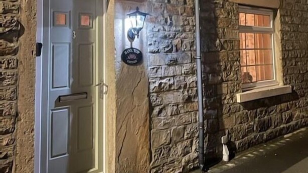A stone building with a white door, a small window, and a wall-mounted light fixture. - Teesdale holiday cottage, sleeps 4 + dog at Bank Top, Mickleton, Barnard Castle (Mickleton)