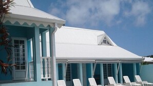 Ein Resort mit Schwimmbad, Liegestühlen und einer Treppe zum Eingang.
