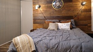 A bedroom with a wooden headboard, a clock, and two wall-mounted lights. - Welcome to the stunning Bergbewohner ski chalet! (Beech Mountain)