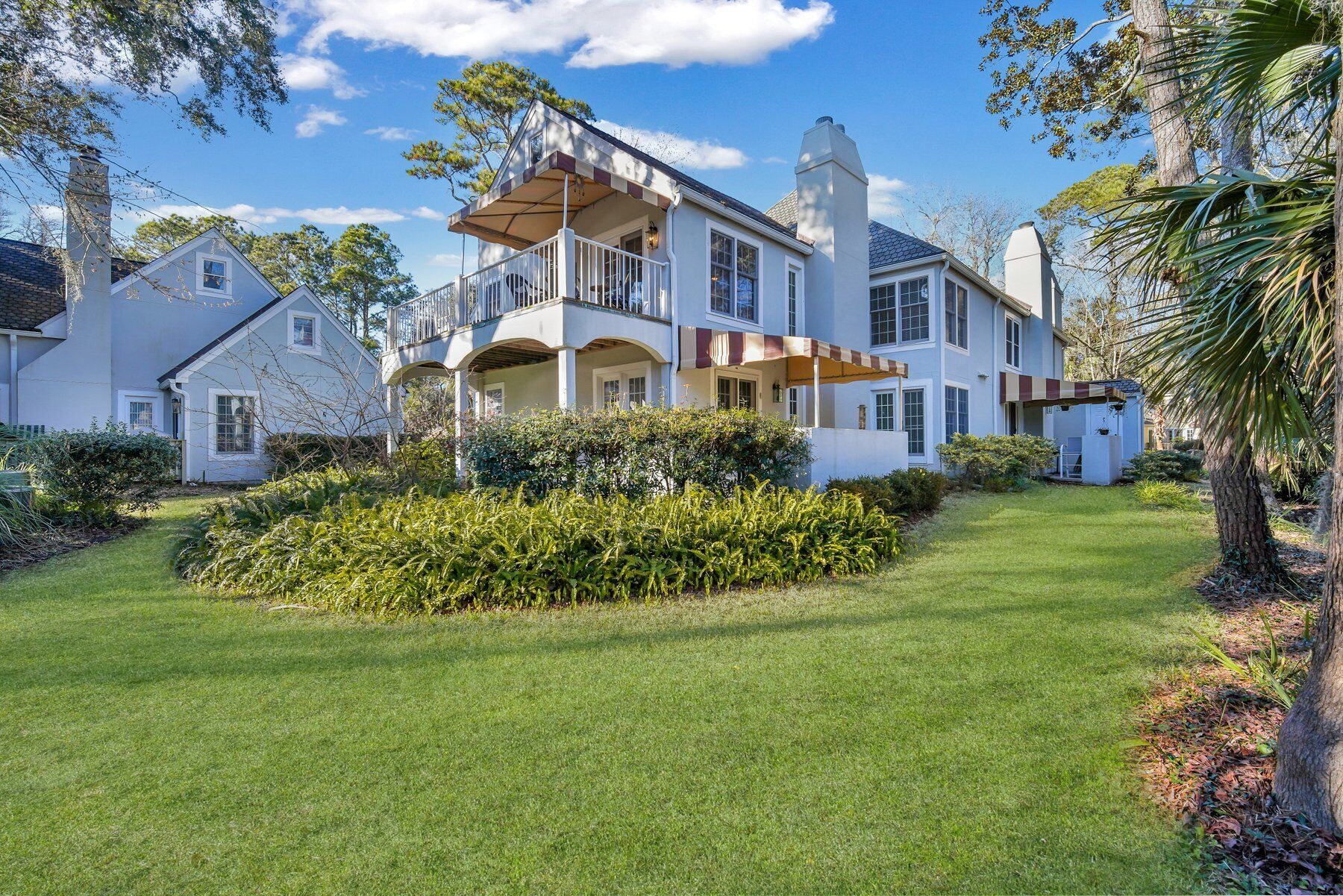 A large, two-story house with a spacious front yard, a covered porch, and a chimney.