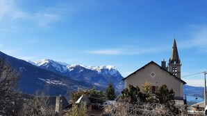 Un paysage de montagne avec une église et un bâtiment au premier plan.