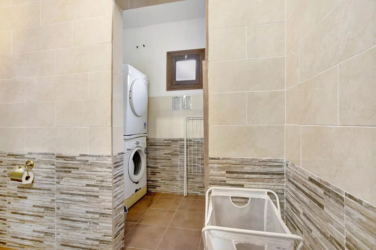 A laundry room with a washing machine, a dryer, and a utility sink.