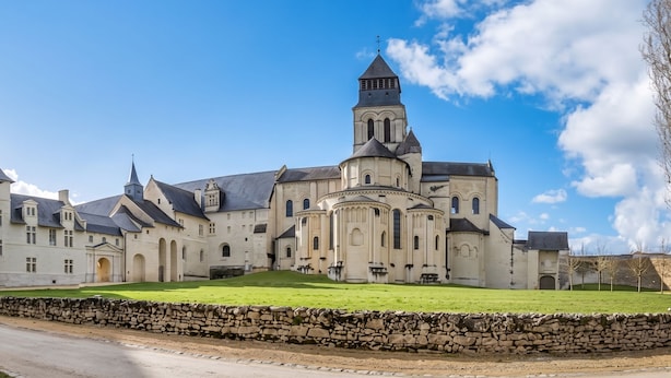 Un grand bâtiment historique doté de nombreuses tours, dont une tour centrale particulièrement imposante.