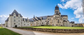 A large, historic building with multiple towers and a prominent central tower.