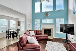 A living room with a sectional sofa, a fireplace, a TV, and a dining area with a table and chairs. - 5 BDRM, Peloton Workout station & Xbox in game RM (Montgomery County)