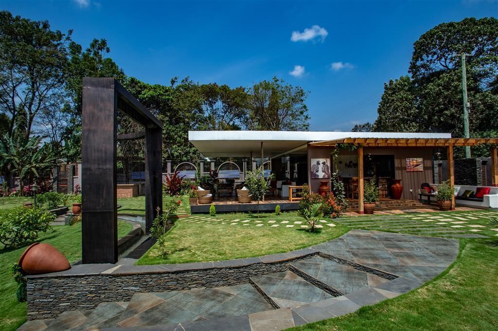 A modern outdoor patio area with a stone pathway, seating, and a covered seating area.