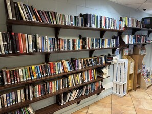 Eine Buchhandlung mit mehreren Holzböden, vollgepackt mit Büchern.