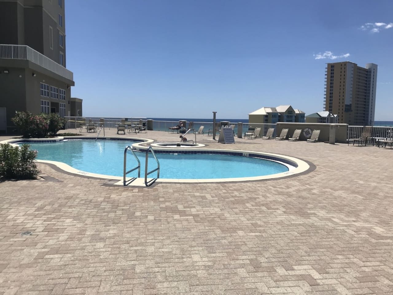 A swimming pool with a circular design, surrounded by a brick patio.