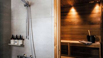 Un baño moderno con ducha, un banco de madera y un estante con botellas.