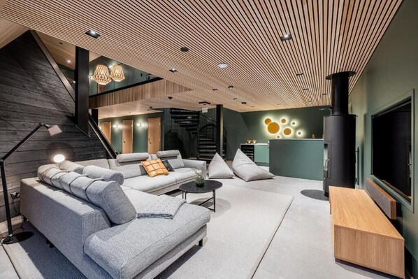 A modern living room with a sectional sofa, a coffee table, and a TV.