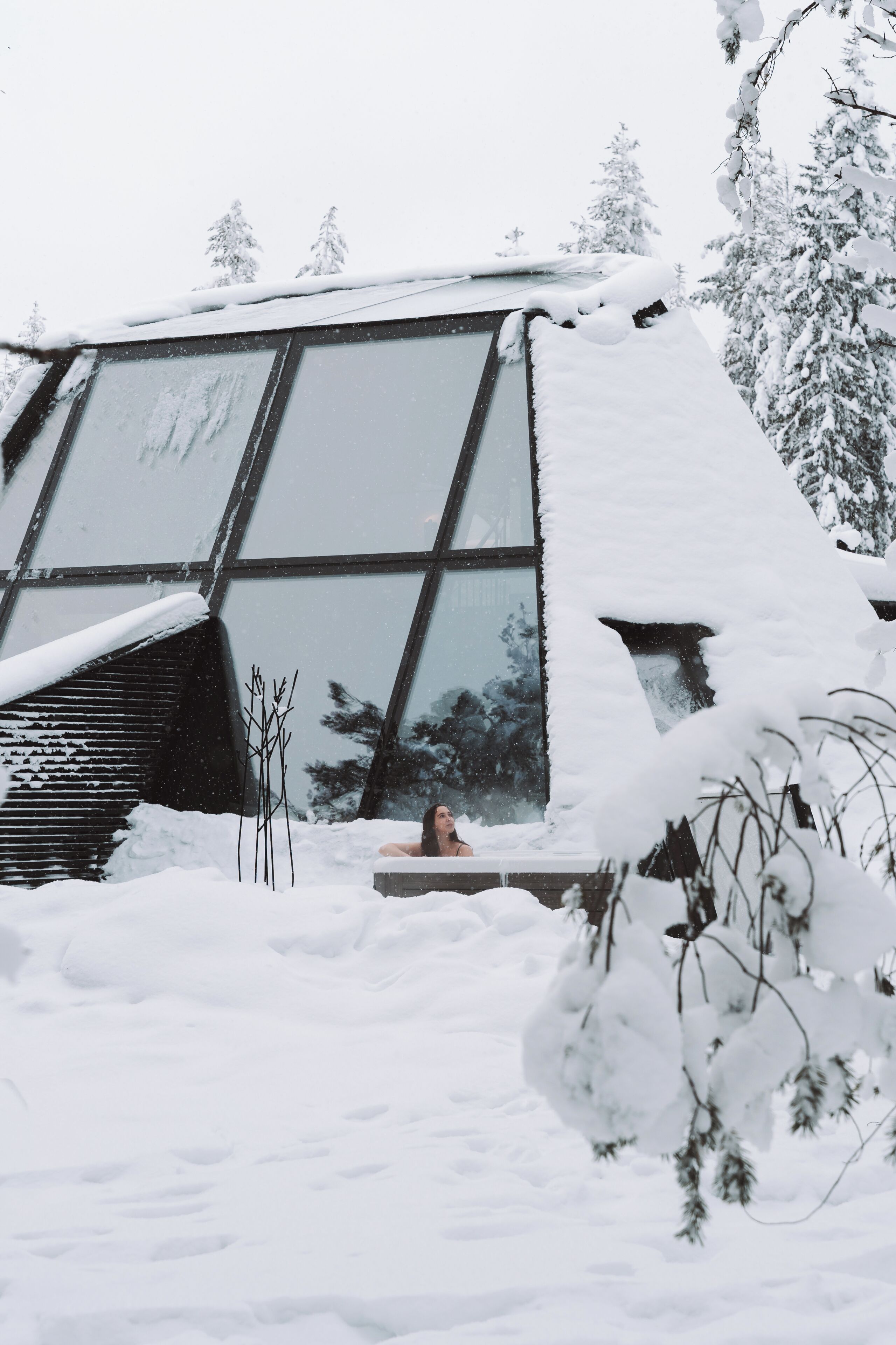 Un edificio con amplias ventanas y techo cubierto de nieve.