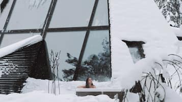 Un edificio con amplias ventanas y techo cubierto de nieve.