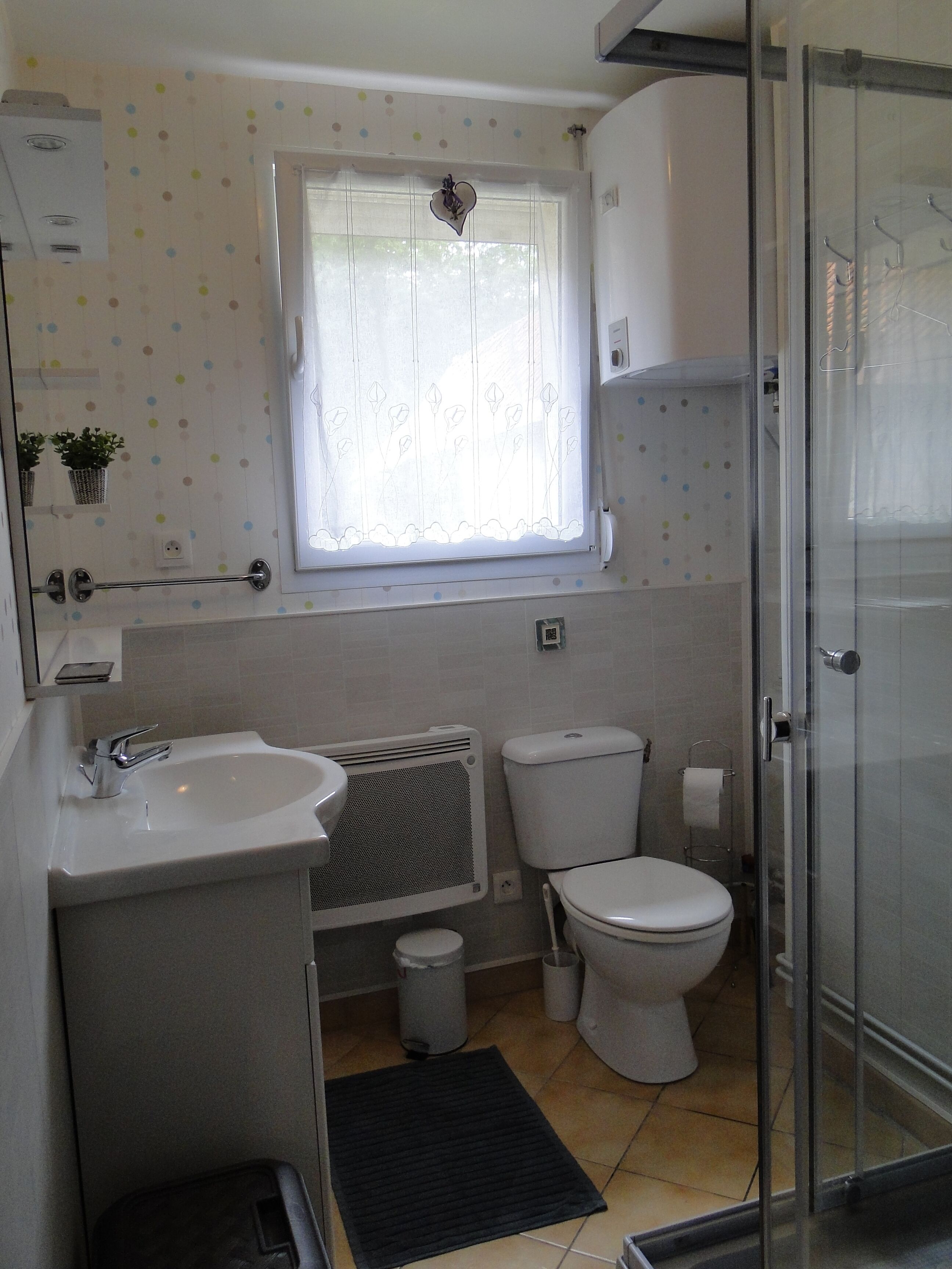 A bathroom with a toilet, sink, and shower.