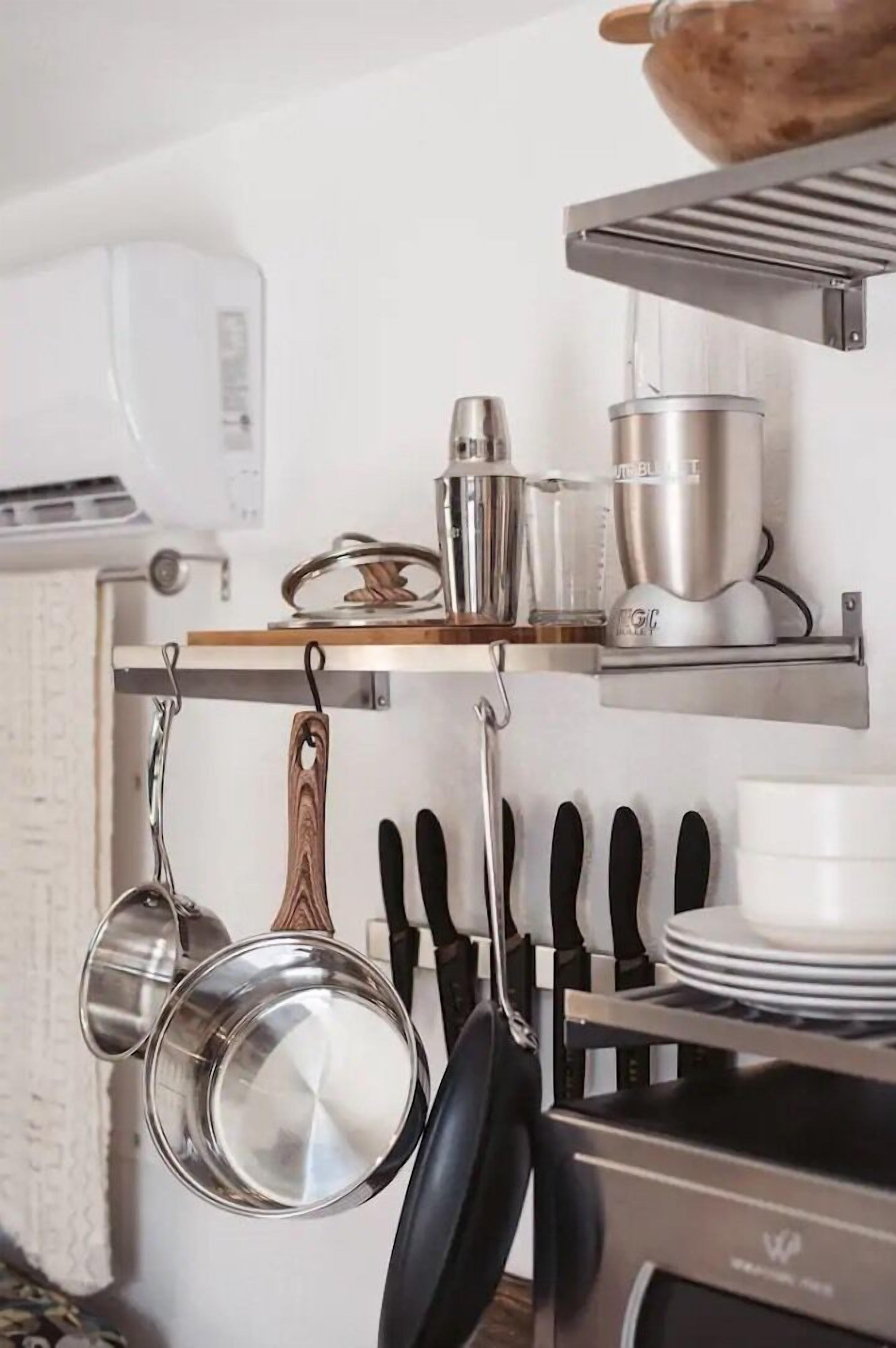 A kitchen with hanging pots and pans, a coffee machine, and a stove.