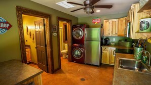 Una cocina compacta equipada con refrigerador, lavadora y cafetera.