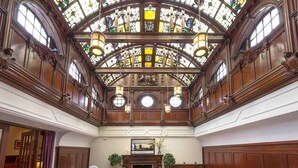 A grand hall with a high arched ceiling, stained glass windows, and wooden paneling. - The Woodside Hotel, Aberdour. Exclusive Use (Burntisland)