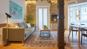 Un salon avec un canapé, une table basse et un mur en pierre.