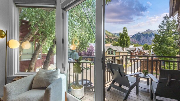 A balcony with a view of mountains, a chair, and a potted plant. - Tri-level condo, close to Coonskin Lift! (Telluride)