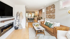 A modern living room with a fireplace, a sofa, a coffee table, and a TV. - Tri-level condo, close to Coonskin Lift! (Telluride)