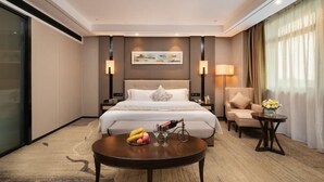 A hotel room with a large bed, bedside tables, a seating area, and a view of the outdoors. - Nanning Guiwanyi Hotel (Beihu South Road Subway Station) (Nanning)