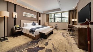 A modern hotel room with a large bed, a desk, a chair, and a TV. - Nanning Guiwanyi Hotel (Beihu South Road Subway Station) (Nanning)