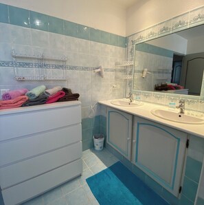 Bathtub, hair dryer, towels, toilet paper