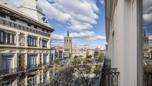 Vista de un edificio histórico con arquitectura ornamentada, que incluye una torre destacada y una fachada detallada.