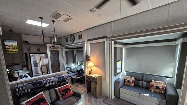 Un intérieur de camping-car compact comprenant un coin cuisine, un espace repas et un coin salon.