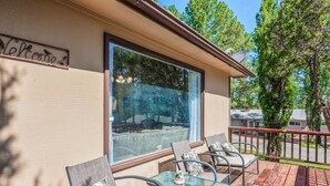 Una terraza con mobiliario exterior y un ventanal grande.