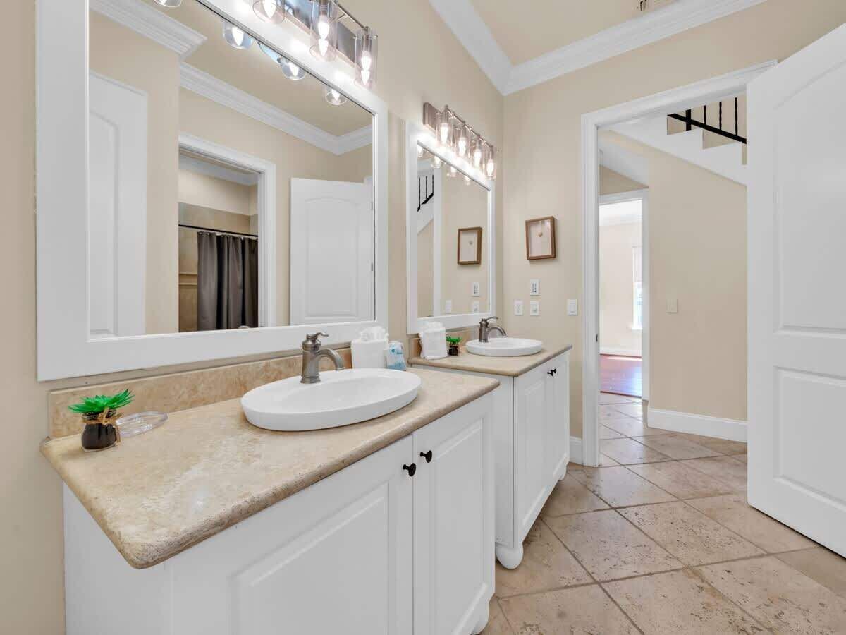 A bathroom with two sinks, a large mirror, and a vanity cabinet.