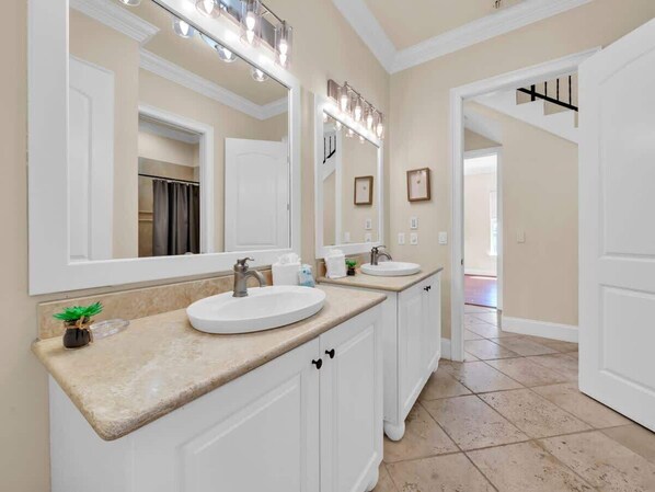 Une salle de bain avec deux lavabos, un grand miroir et un meuble-lavabo.