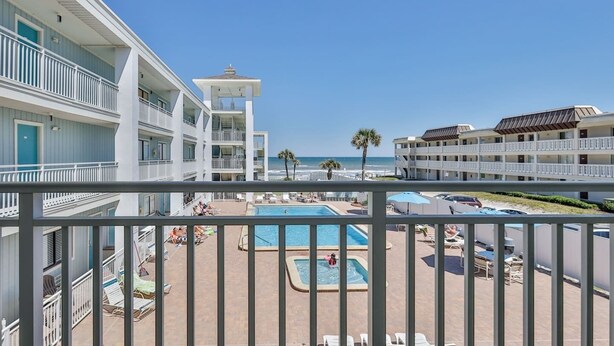 A hotel with a pool area, multiple balconies, and a view of the beach. - 2 Bedroom Kitchen Suite#203/204 (New Smyrna Beach)