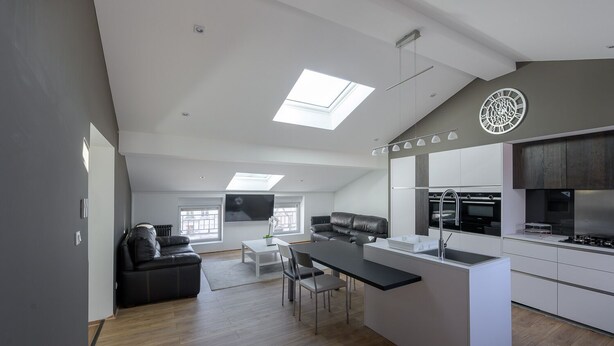 Eine moderne Loft-Wohnung mit Küche, Essbereich und Wohnraum.