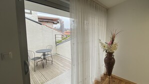 Ein Zimmer mit einer Schiebetür, die auf einen Außenbereich mit Tisch und Stühlen führt.